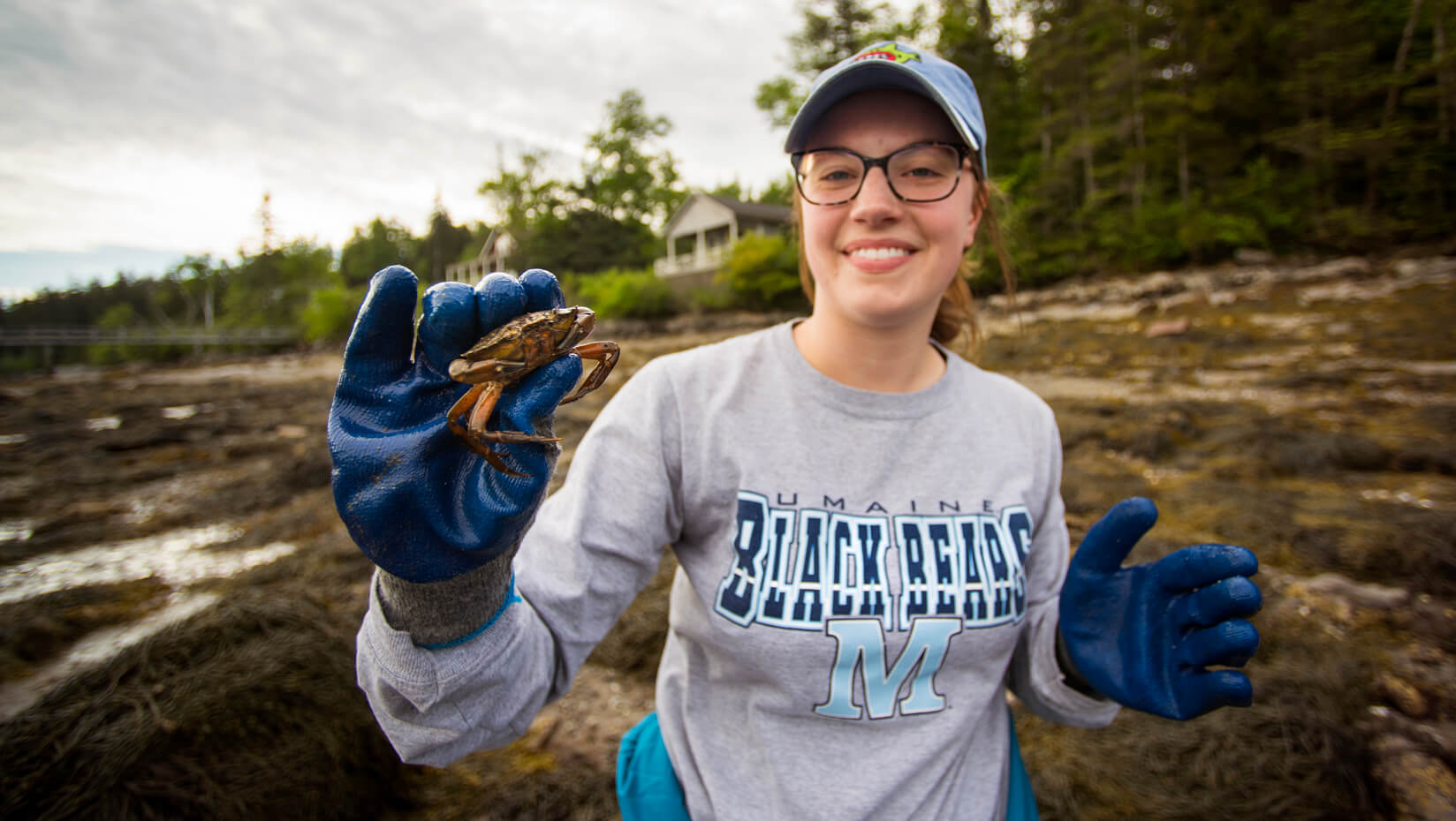 student in tidal area with green crab