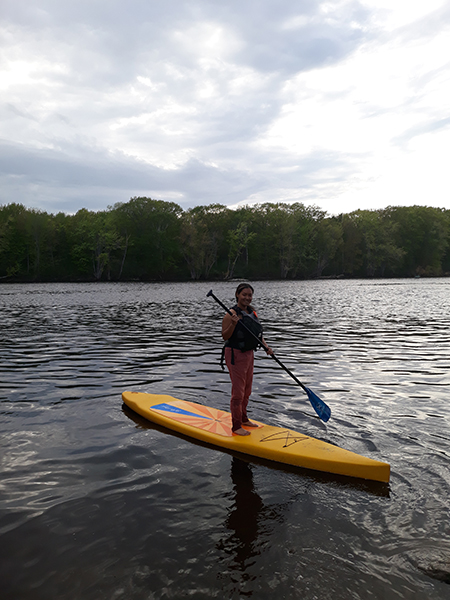 Morelys Rodriguez on a standup paddle board on the Stillwater River