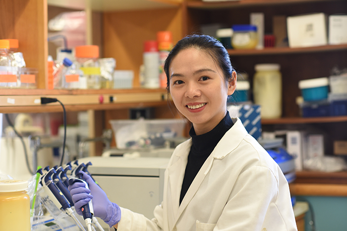 Tonling Ge in a laboratory holding a pippette.