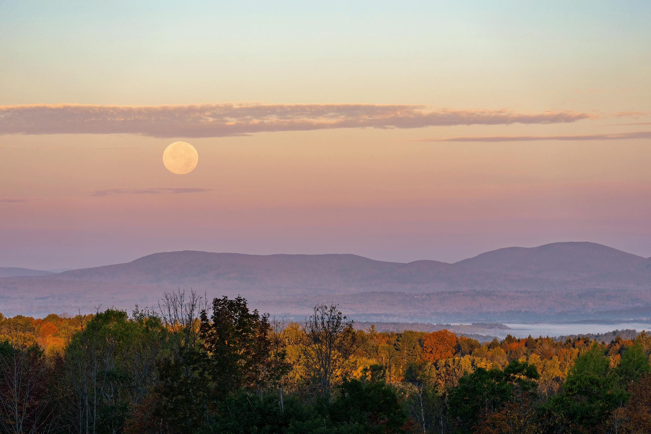 moon and clouds sit above bigelow range