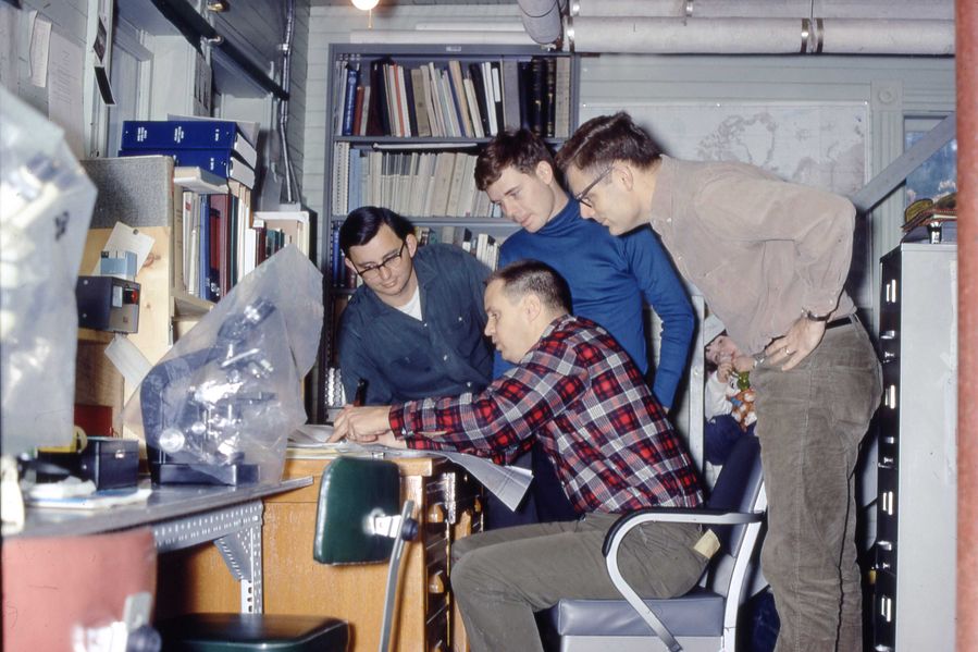 four researchers gather around a desk in the basement of Darling Marine Center